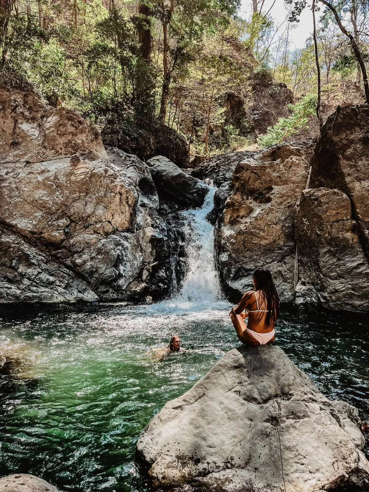 Swimming in a jungle waterfall pool